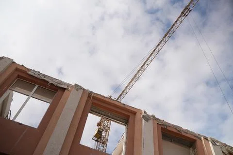 Tower crane next to the destroyed wall Stock Photos