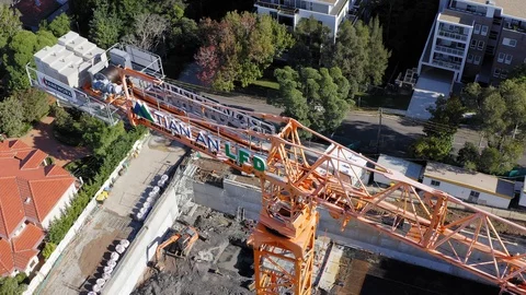 Tower crane operating over a new construction site for an apartment block Stock Footage 107507991