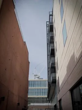 A tower crane seen framed by mixed modern glass and brick office buildings Stock Photos