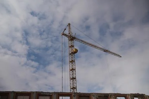 A tower crane stands over a destroyed building Stock Photos