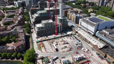 Tower crane stands over a residential construction site beside completed 動画素材 343467752