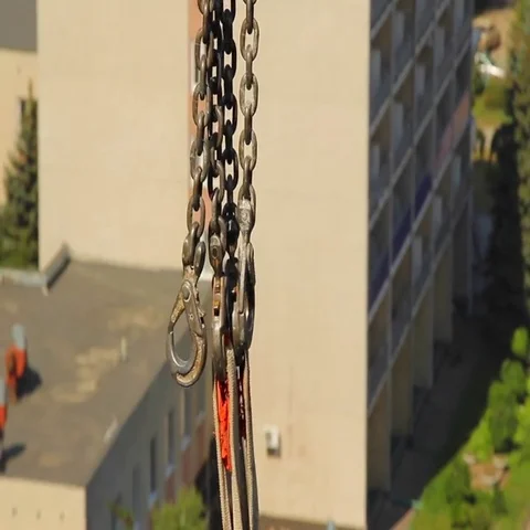 Tower crane swinging chains and hooks on city landscape background Vídeo Stock 69484457