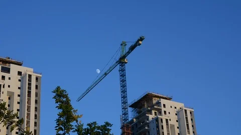 Tower crane on top of a building under construction with moving clouds in the ba 스톡 동영상 94043045