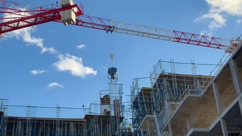 Tower crane transporting a concrete bucket on a construction site Stock Footage 326092490