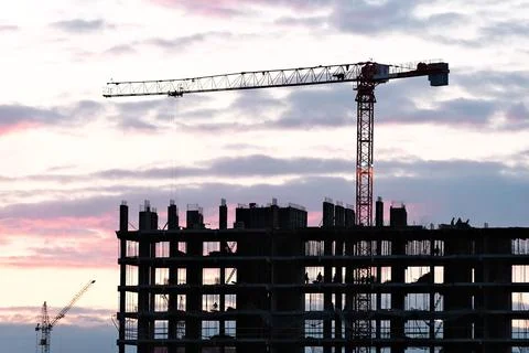 Tower crane, workers work at construction site. Process of building new houses Stock Photos