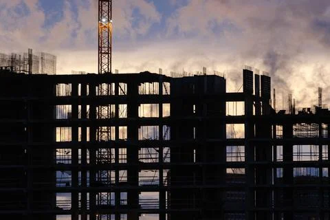 Tower crane, workers work at construction site. Process of building new houses Stock Photos