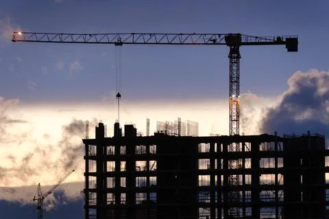 Tower crane, workers work at construction site. Process of building new houses Stock Photos