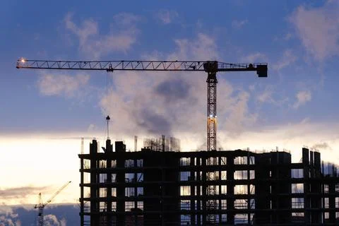 Tower crane, workers work at construction site. Process of building new houses Stock Photos