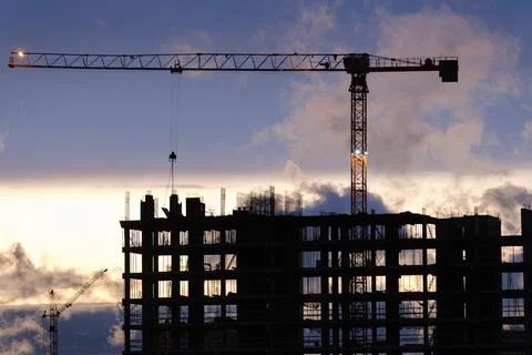 Tower crane, workers work at construction site. Process of building new houses Stock Photos