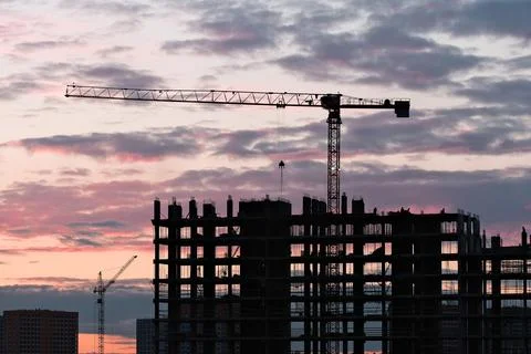 Tower crane, workers work at construction site. Process of building new houses Stock Photos