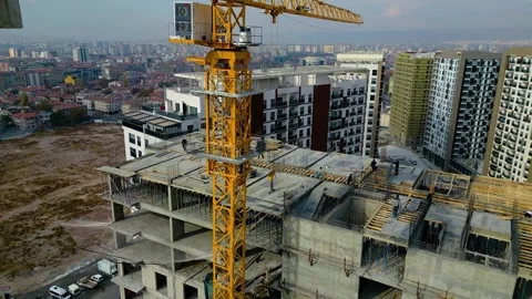 Tower crane working on a multi-story construction site Stockbeeldmateriaal 292621650