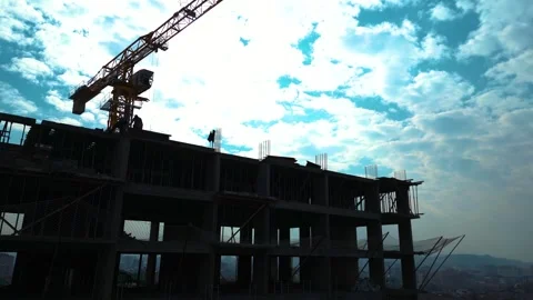 Tower crane working on a multi-story construction site Stockbeeldmateriaal 292624070