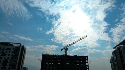 Tower crane working on a multi-story construction site Stockbeeldmateriaal 292627752