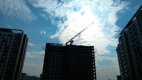 Tower crane working on a multi-story construction site Stockbeeldmateriaal 292628170