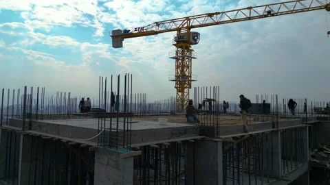 Tower crane working on a multi-story construction site Stockbeeldmateriaal 292630131