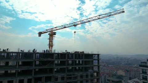 Tower crane working on a multi-story construction site Stockbeeldmateriaal 292630375