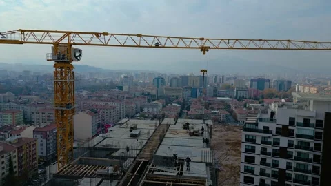 Tower crane working on a multi-story construction site Stockbeeldmateriaal 292630594