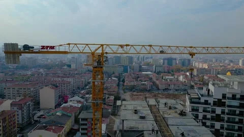 Tower crane working on a multi-story construction site Stockbeeldmateriaal 292631343