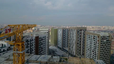 Tower crane working on a multi-story construction site Stockbeeldmateriaal 292631367
