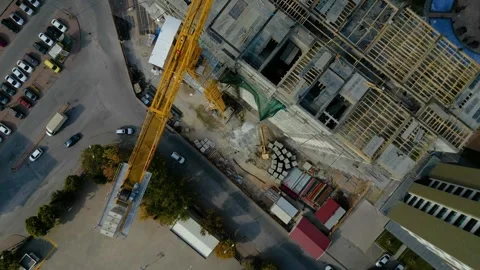 Tower crane working on a multi-story construction site Stockbeeldmateriaal 292632358