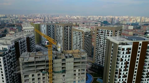 Tower crane working on a multi-story construction site Stockbeeldmateriaal 292632783
