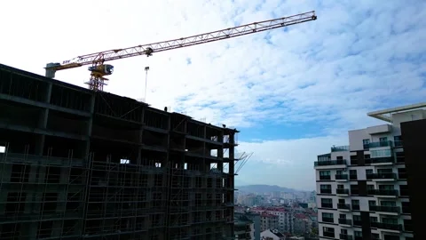 Tower crane working on a multi-story construction site Stockbeeldmateriaal 292788255