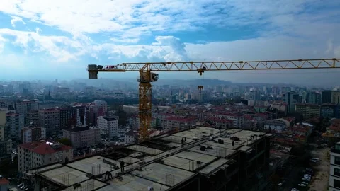 Tower crane working on a multi-story construction site Stockbeeldmateriaal 292788379