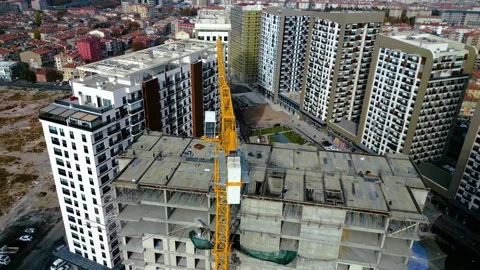 Tower crane working on a multi-story construction site Stockbeeldmateriaal 292788431