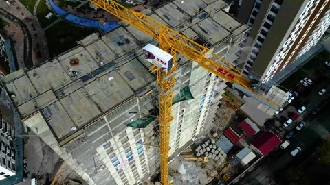 Tower crane working on a multi-story construction site Stockbeeldmateriaal 292788682