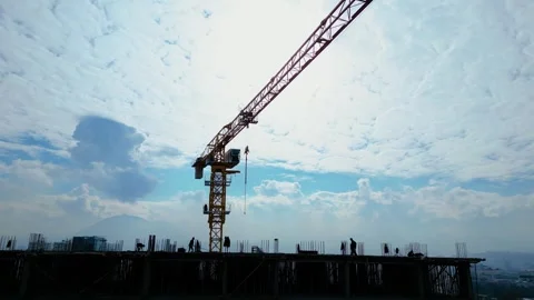 Tower crane working on a multi-story construction site Stockbeeldmateriaal 292790066