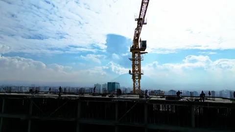 Tower crane working on a multi-story construction site Stockbeeldmateriaal 292790350