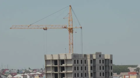 A tower crane works at a construction site Stock Footage 133622010