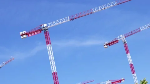 Tower cranes against clear blue sky at construction site Stock Footage 335484969