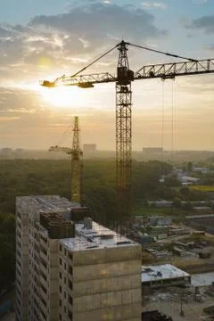 Tower cranes and building construction site at sunrise. Stock Photos