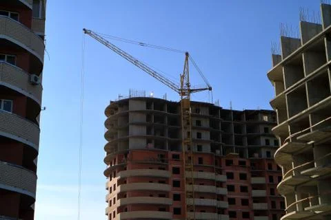 Tower cranes are working on the construction of a new house. Tower cranes are Stock Photos