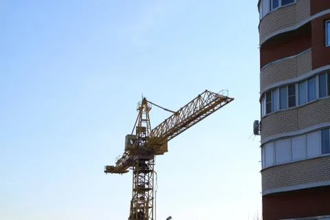 Tower cranes are working on the construction of a new house. Tower cranes are Stock Photos