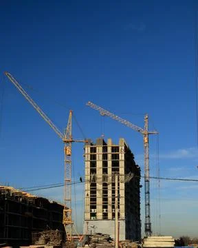 Tower cranes are working on the construction of a new house. Lifting crane. Stock Photos