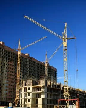 Tower cranes are working on the construction of a new house. Lifting crane. Stock Photos