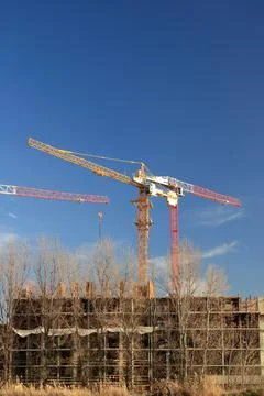 Tower cranes are working on the construction of a new house. Lifting crane. Stock Photos