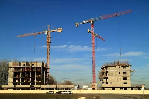 Tower cranes are working on the construction of a new house. Lifting crane. Stock Photos