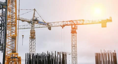Tower cranes on the background of the cooling tower. Stock Photos