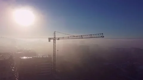 Tower cranes on a construcion site with dense fog aerial view Video stock 219629080