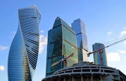 Tower cranes on the construction of a building on the background of skyscrapers Stock Photos