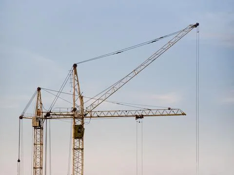 Tower cranes at construction site with clear sky background Фото