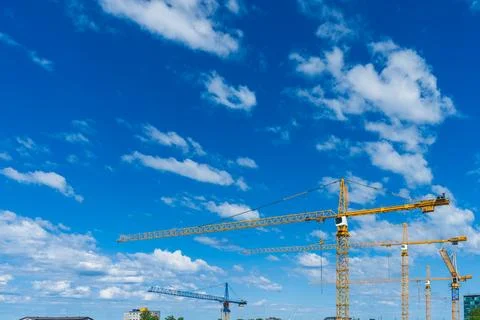 Tower cranes over blue sky as urban construction boom and real estate devel.. 库存照片