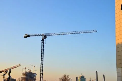 Tower cranes over city construction skyline at sunset 스톡 사진