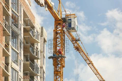 Tower cranes work during the construction of a multi-story building. New Stock Photos