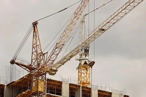 Tower cranes work during the construction of a multi-story building. New ap.. Stock Photos