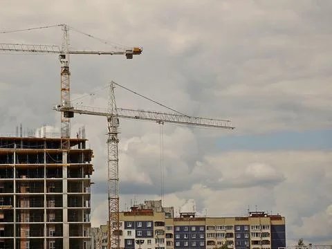 Tower cranes work during the construction of a multi-story building. New ap.. Stock Photos