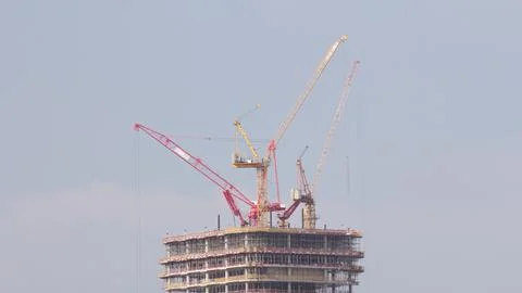 Tower cranes working on the construction site of new skyscraper high-rise b.. Fotos Stock